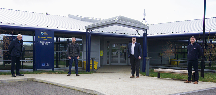 L-R: Cllr Bob Parry (Property portfolio holder) and Cllr Carwyn Jones (Economic Development portfolio holder) welcome Ifan Rowlands (Cadarn Consulting Engineers) and Gethin Williams (Anglesey Builders) to the newly expanded Anglesey Business Centre in Llangefni.