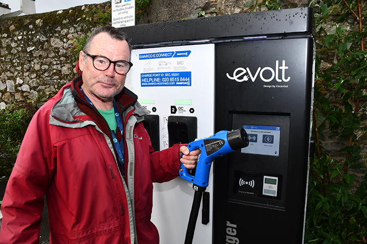 An Anglesey councillor using an electric vehicle charging point