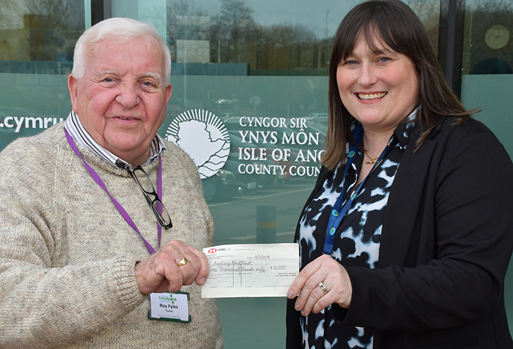 A cheque for £6,000 being presented to Anglesey Foodbank