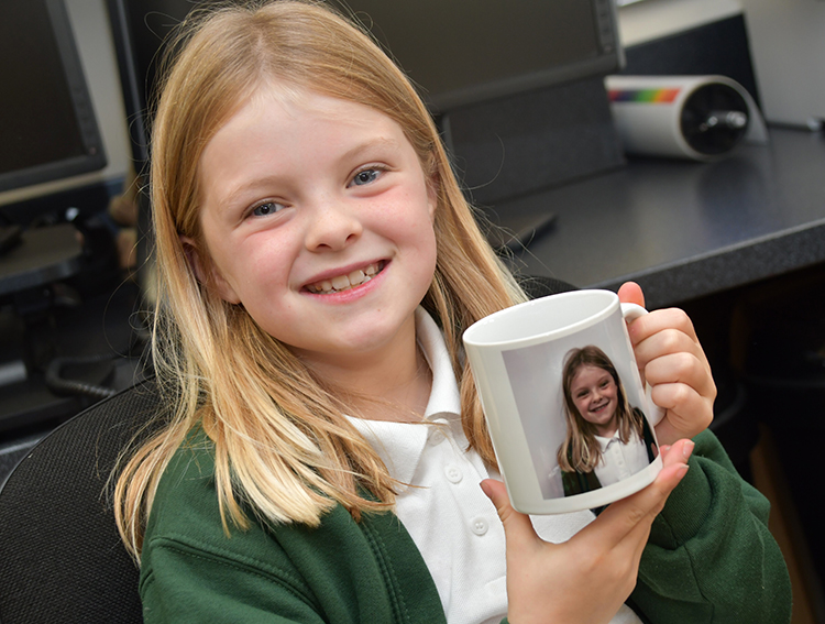 A young girl holding a mug. 