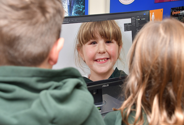 An image of a young girl on a computer screen smiling.